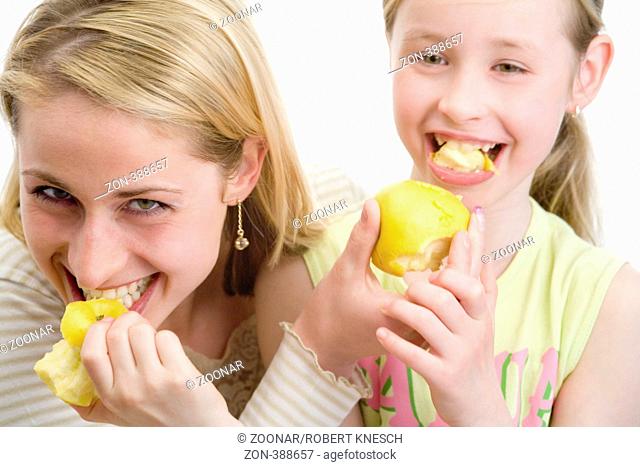 Mother and daughter eating apples