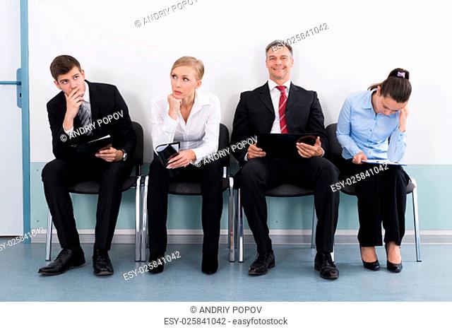 Businesspeople Sitting On Chair Waiting For Job Interview In Office