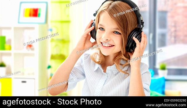 happy smiling girl with headphones at home