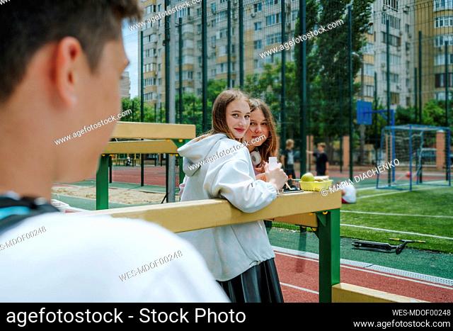 Girls looking at boy in schoolyard