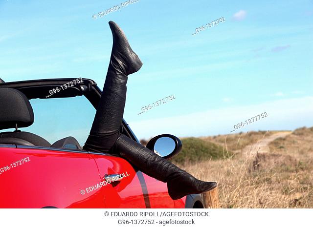 woman in a convertible relaxing at the beach