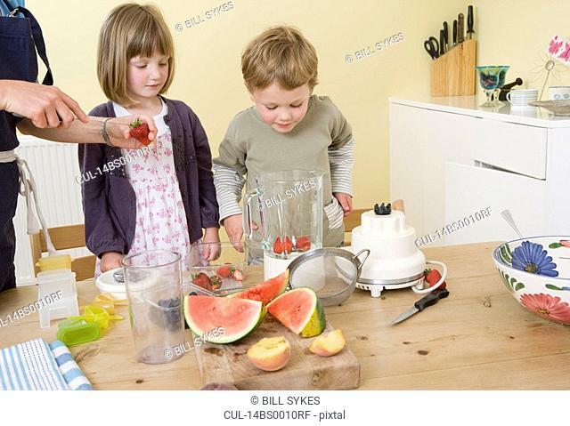 boy and girl preparing fruit smoothies