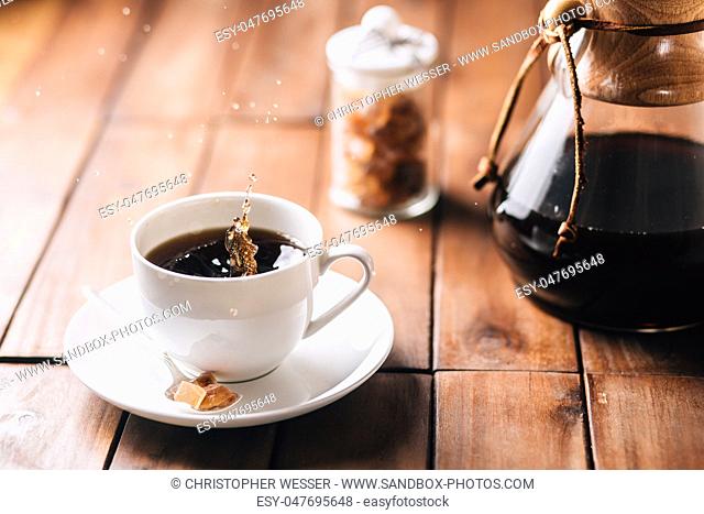Coffee splashing in a tabletop scene on a wooden table