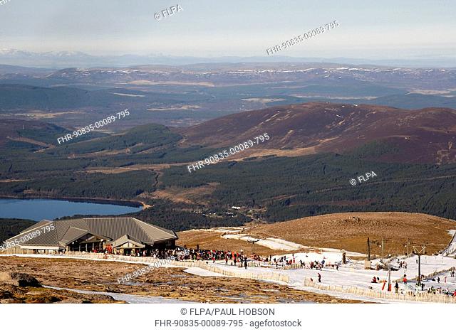 View with restaurant and skiers on remaining snow, upland habitat, Ptarmigan Restaurant, Cairn Gorm, Cairngorms, Highlands, Scotland