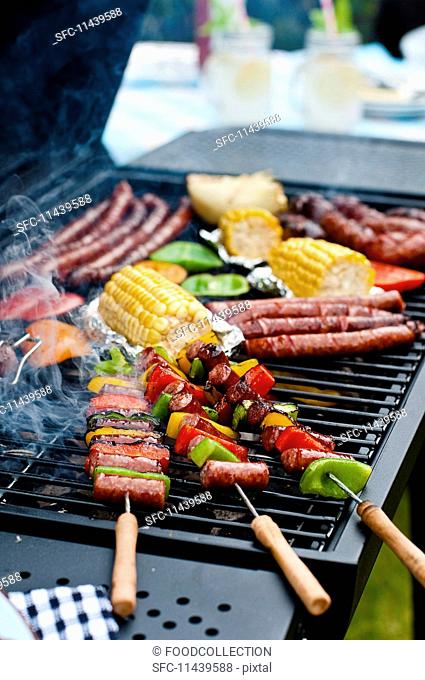 Sausage kebabs, sausages and vegetables on a barbecue