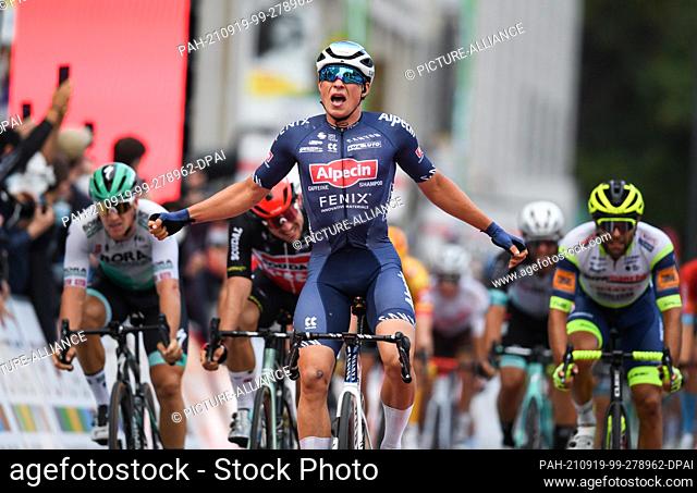 19 September 2021, Hessen, Frankfurt/Main: Belgian Jasper Philipsen (M) of Team Alpecin Fenix cheers at the finish of the UCI WorldTour cycling race...