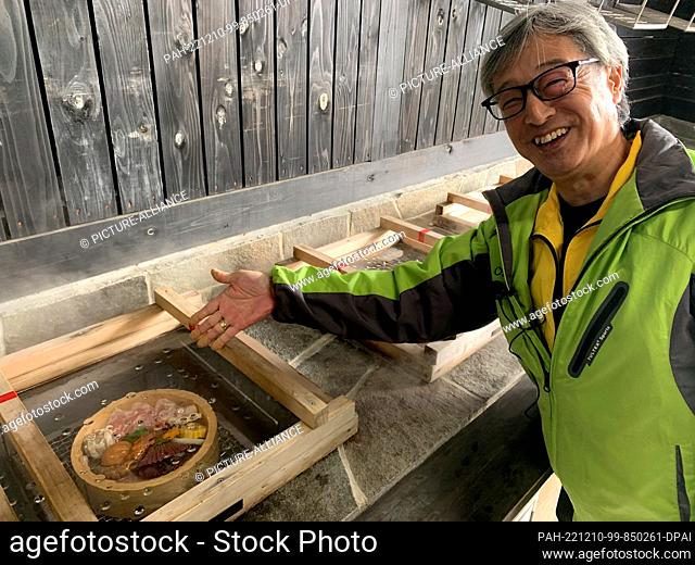 09 December 2022, Japan, Beppu: Hitoshi Tanaka, head of the famous Hyotan Onsen, explains the traditional cooking method ""Jigoku Mushi"" (""hell-steamed"")