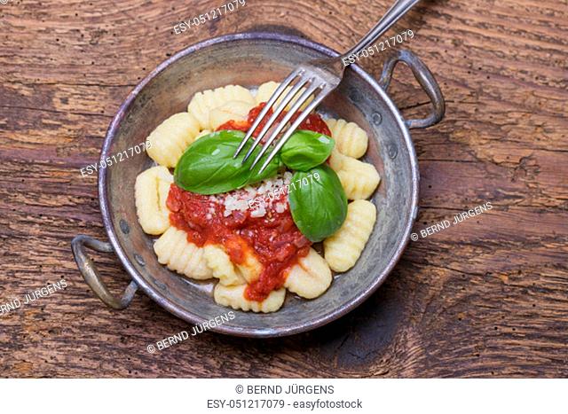 closeup of gnocchi with sauce on wood