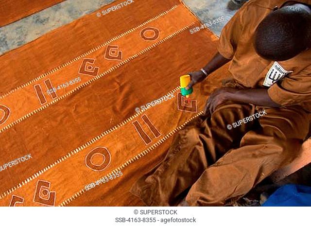 MALI, SEGOU, PRODUCTION OF TRADITIONAL BAMBARA BOGOLAM MUD CLOTH, FABRIC BEING PREPARED FOR DYEING