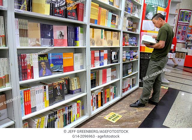 China, Beijing, Wangfujing Xinhua Bookstore, shopping, inside, sale, books, shelves, Asian, man, browsing, Chinese characters hànzì pinyin,