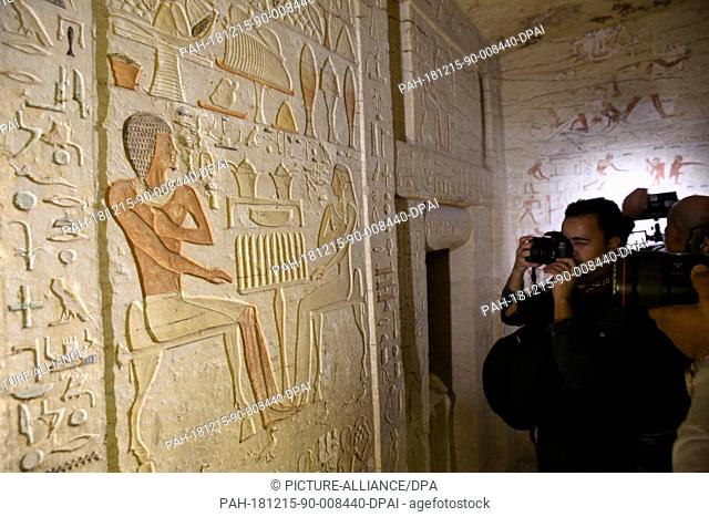 15 December 2018, Egypt, Giza: A photographer shoots inside achamber of recently uncovered tomb of the Fifth Dynasty royal Priest during the reign of King Nefer...