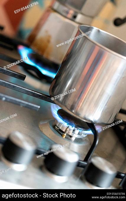 Close up of a blue gas flame, cooking a water pot in kitchen