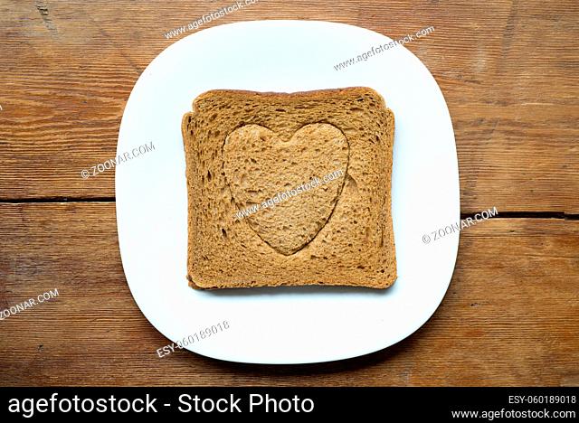 square grilled toast with heart symbol embossing on white plate