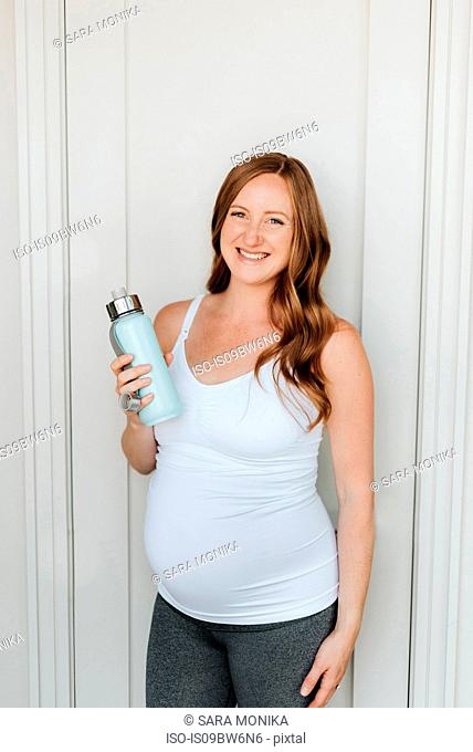 Pregnant woman holding water bottle