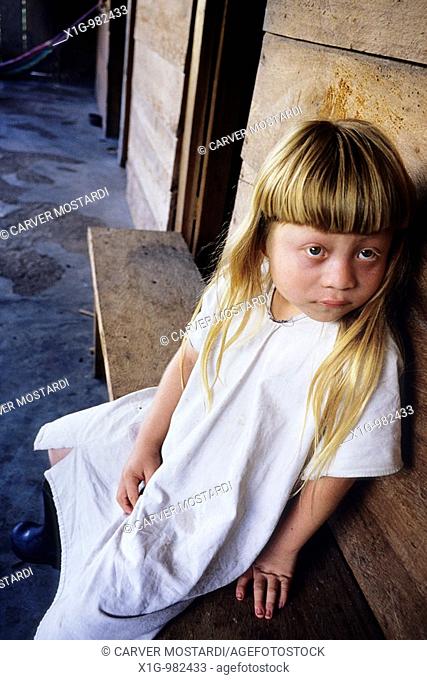 Albino Lacandon Indian Hach Winik boy Chan Bor sitting at the doorway to his house in the village of Nah‡, Mexico