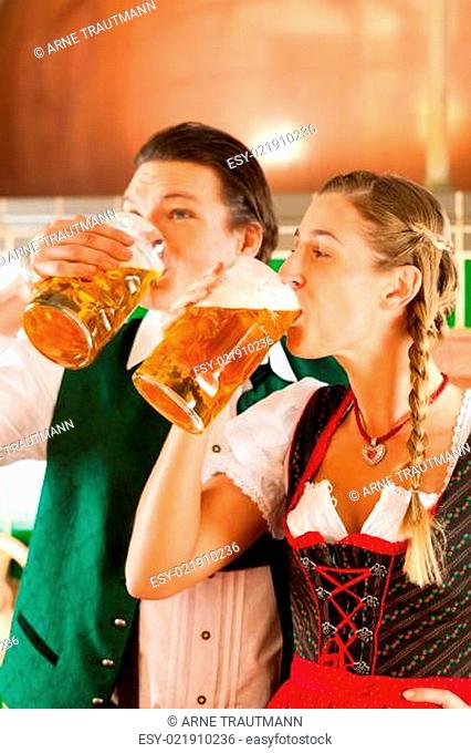 Paar in Tracht mit Bier Glas in Brauerei