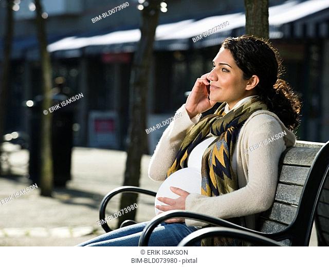 Pregnant Middle Eastern woman talking on cell phone