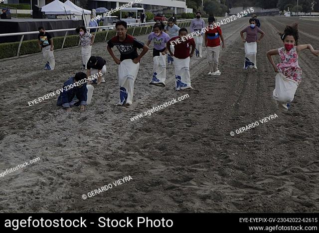 MEXICO CITY, MEXICO - APR 23, 2022: Children have fun during sack race as part to Botarga contest at the Hipódromo de las Américas