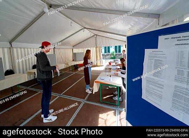 15 May 2022, North Rhine-Westphalia, Stolberg: Voters stand in a tent used as a polling station. After the floods in the summer of 2021