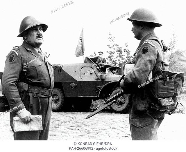 Two soldiers of the British army stand in front of an armoured vehicle from the Soviet zone in Berlin-Spandau on the 21st of August in 1961