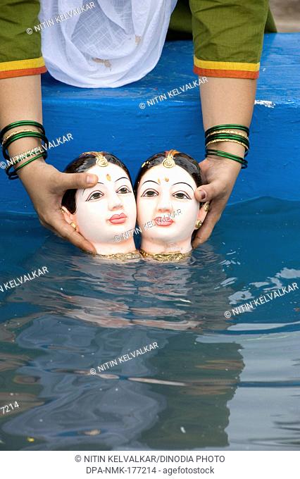 Woman doing immersion of goddess gauri in artificial tank at pune , Maharashtra , India
