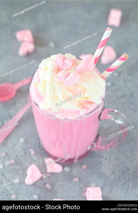 Glas rosa Milkshake mit Schlagsahne und Marshmallows