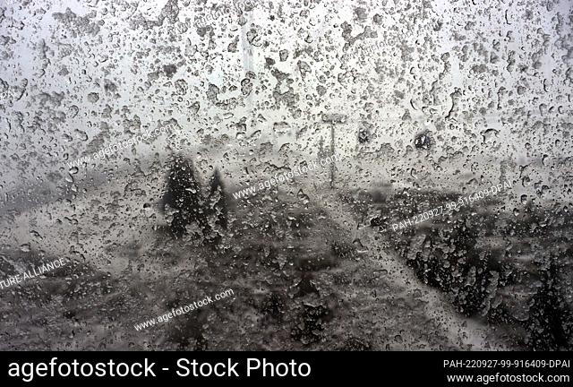 dpatop - 27 September 2022, Bavaria, Oberstdorf: View through the snow-covered window pane of a gondola of the Fellhorn cable car onto the landscape covered...