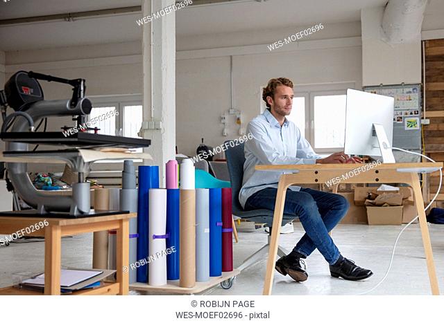 Young businessman working on desk, using computer