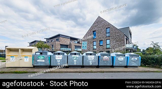 05 August 2023, Schleswig-Holstein, Bargtheide: Recycling containers for glass, paper and used clothing are located in a new development