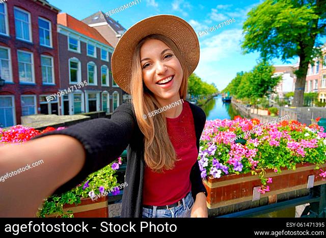 Tourist girl taking self portrait on canal in The Hague, Netherlands