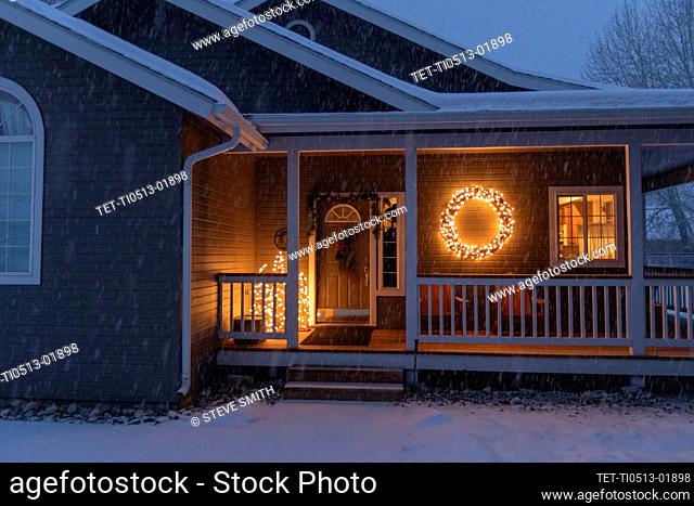 USA, Idaho, Bellevue, Porch decorated with Christmas lights during snow storm
