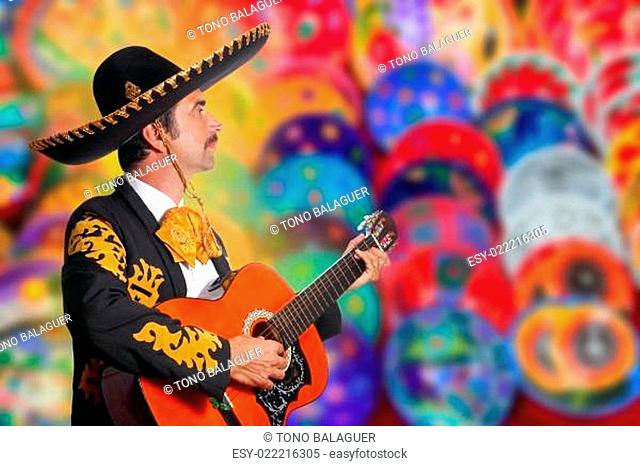 Charro Mariachi playing guitar over colorful blur