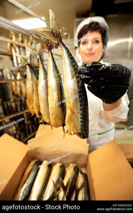 September 18, 2020. Belarus, Gamil. Fish factory.Fish factory worker with smoked fish. Fish industry