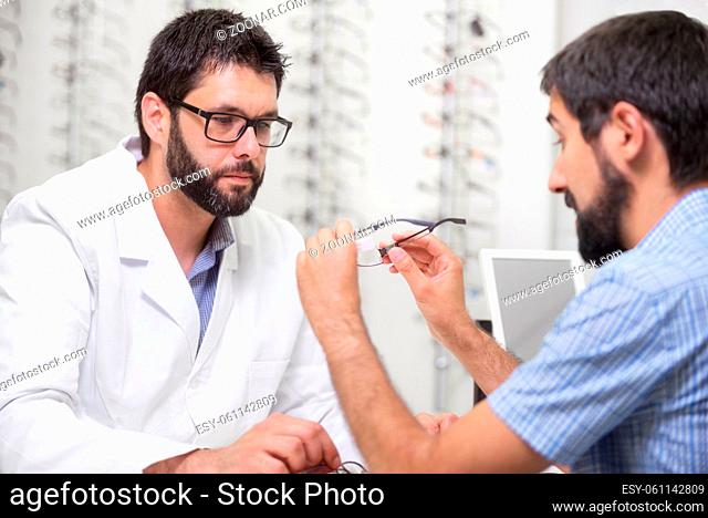 ophthalmologist offering eyeglasses for a try out. Optometrist offering to wear a pair of glasses