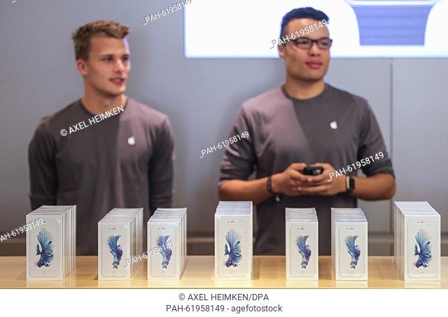 Employees of an Apple Store arrange dozens of new iPhone 6S phones on the shop counter in Hamburg, Germany, 25 September 2015