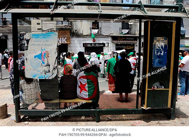 05 July 2019, Algeria, Algiers: Algerians hold national flags and placrds as they take part in a march calling for the departure of the Algerian regime...