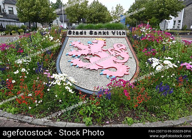 28 May 2023, Belgium, Sankt Vith: The coat of arms of Saint Vith decorates with flowers a traffic circle at the entrance to the town
