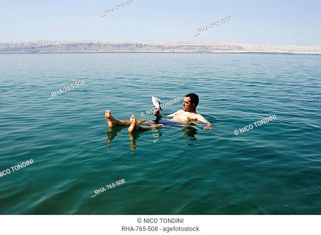 Tourist reading a book, Dead Sea, Jordan, Middle East