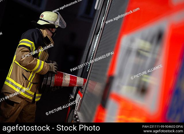 ILLUSTRATION - 08 November 2023, Baden-Württemberg, Stuttgart: A firefighter takes a pylon from an emergency vehicle of the Stuttgart Fire Department during a...