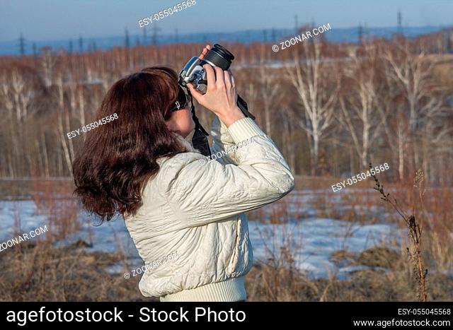 A girl takes pictures with a digital SLR camera