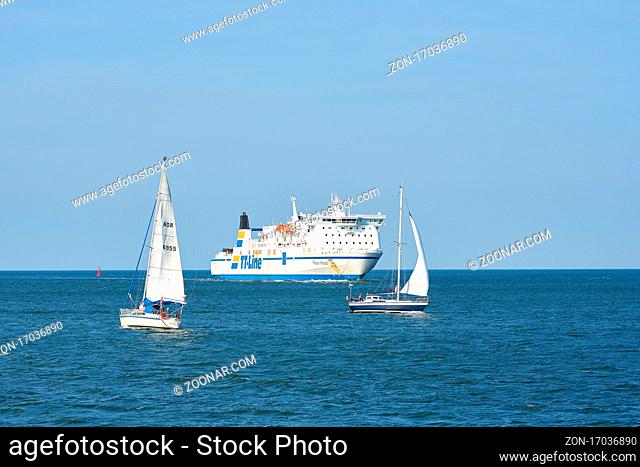 Die Fähre Robin Hood und Segelboote auf dem Weg in den Hafen von Swinemünde an der polnischen Ostseeküste