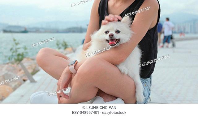 Pet owner with her Pomeranian dog at outdoor park