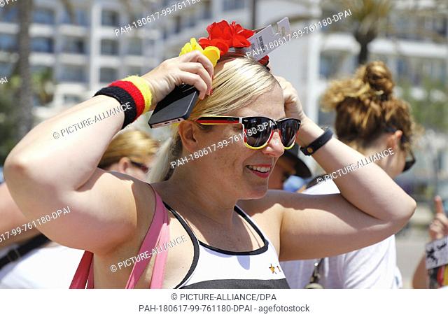 17 June 2018, Spain, Palma de Mallorca: Katja Scheiner buying a headband to animate the German team before the soccer World Cup game between Germany and Mexico...