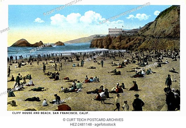 Cliff House and beach, San Francisco, California, USA, 1921. Vintage postcard showing a beach with hundreds of bathers and the Cliff House on the rocks in the...