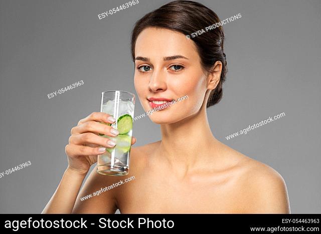 woman drinking water with cucumber and ice