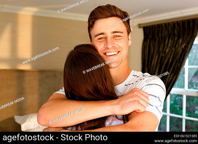 Caucasian couple embracing man smiling woman with back to camera