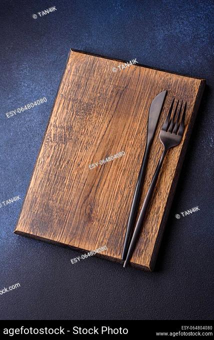 Empty rectangular wooden cutting board on dark concrete background. Cooking at home