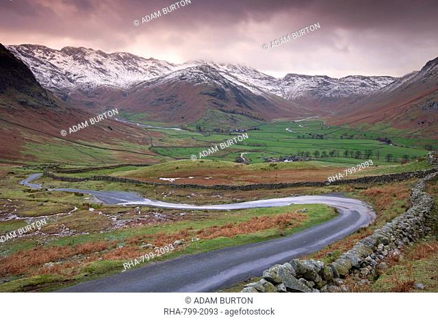 Small winding road leading into the Langdale Valley, surrounded by snow clad mountains, Lake District National Park, Cumbria, England, United Kingdom, Europe