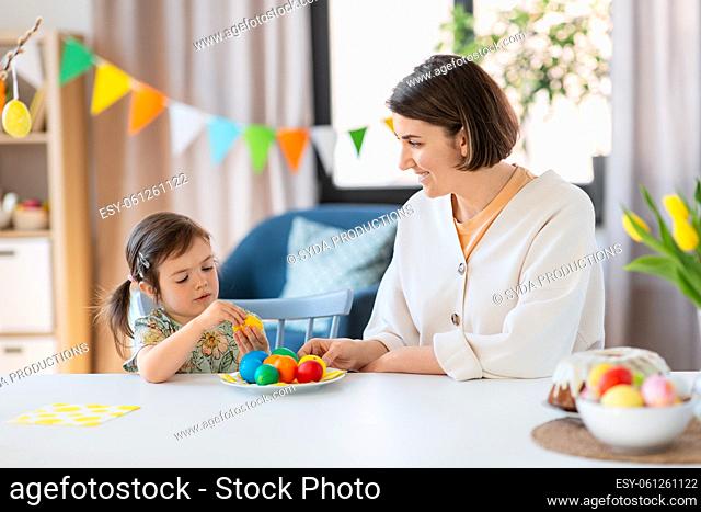 mother and child with colored easter eggs at home