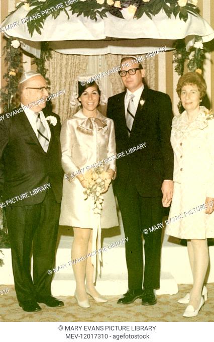 Four people at a Jewish wedding, with bride and groom in the centre